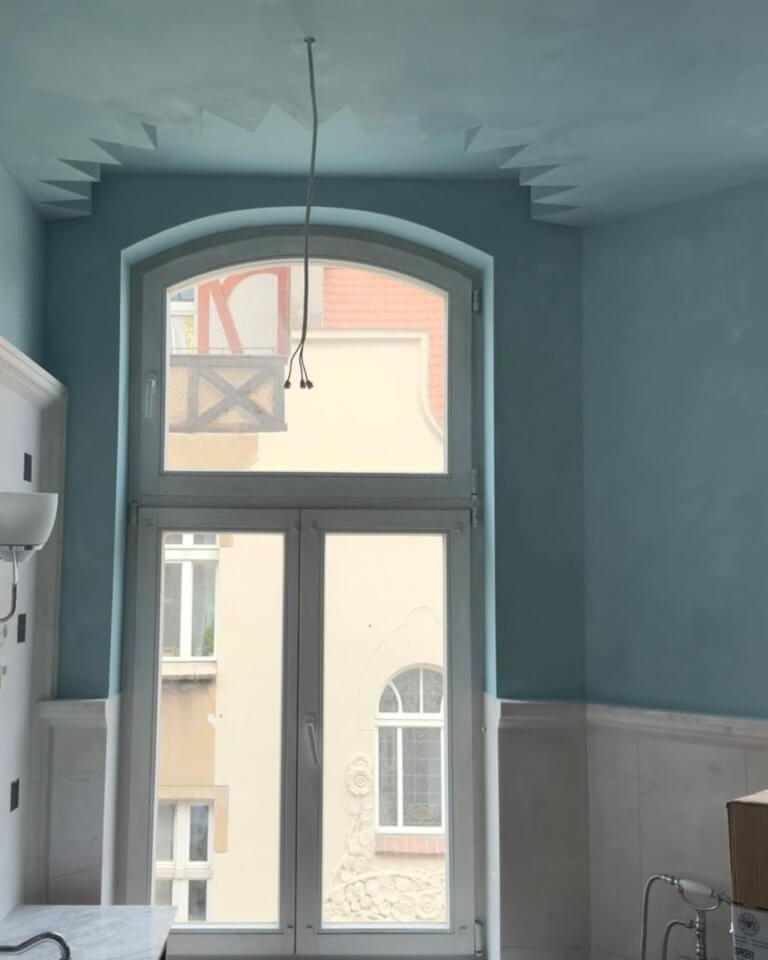 Applying Limewash paint in cross-hatch pattern over textured surface